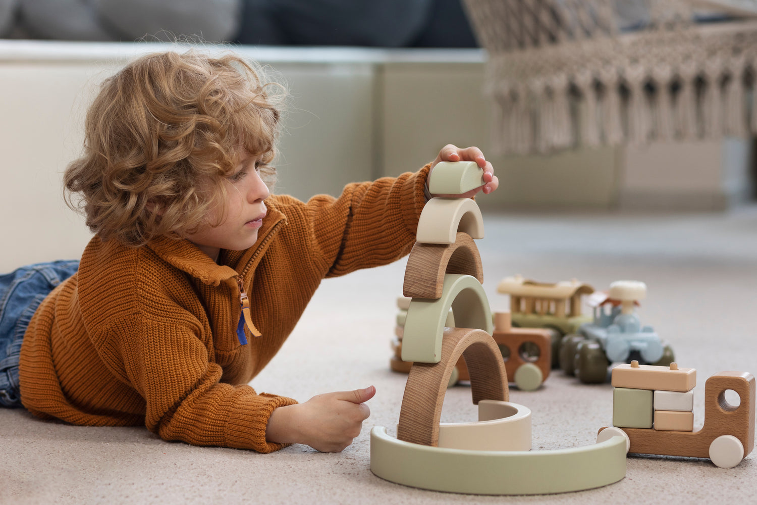 Child playing with wooden toys on a carpeted floor