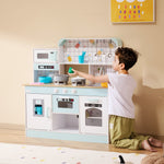 Young boy playing with pastel wooden kids kitchen playset Australia featuring stove oven sink and utensils