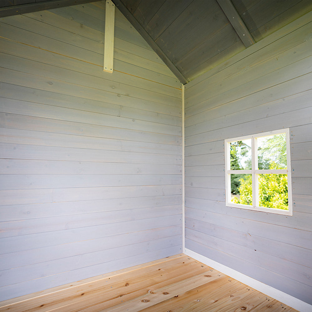 Interior of wooden cubby house with slide Australia pale blue paneled walls small window and timber floor